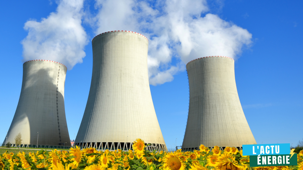 Une centrale nucléaire avec trois grandes tours de refroidissement d'où s'échappe de la vapeur sous un ciel bleu